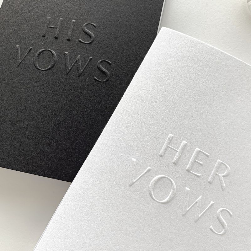 Papieren geloftenboekjes met zwarte omslag "his vows" en witte omslag "her vows"